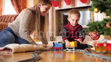 小蹒跚学步的男孩在圣诞树下的地板上玩耍时，把玩具车连接到<strong>火车</strong>上的4k镜头。 <strong>儿童</strong>
